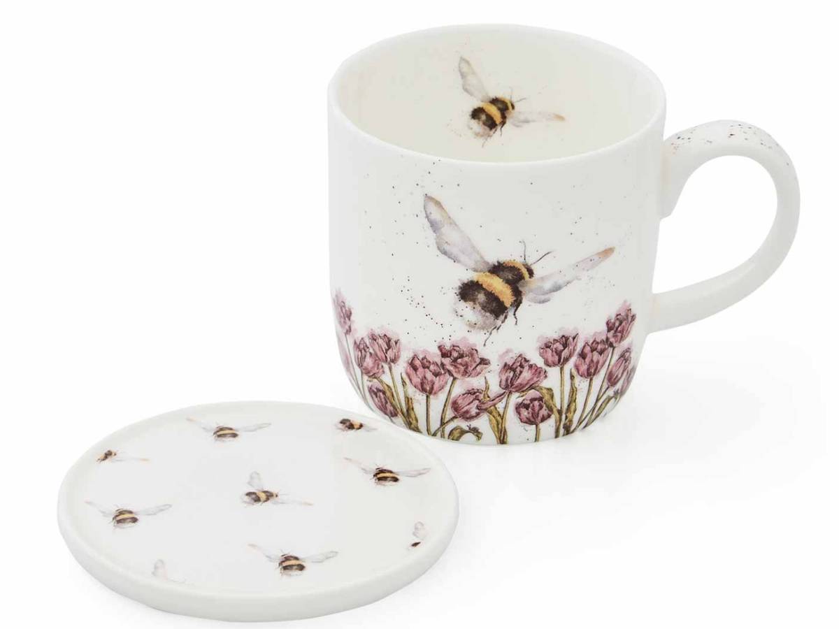 A white ceramic mug with a matching lid, decorated with watercolor-style bumblebees and pink flowers, shown on a clean white background.