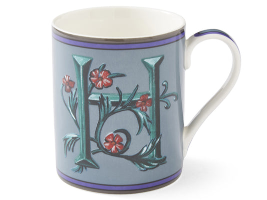 Crafted by renowned British designer Kit Kemp, this blue mug takes inspiration from her unique alphabet paintings, showcasing a lush green initial adorned with winding red flowers. 