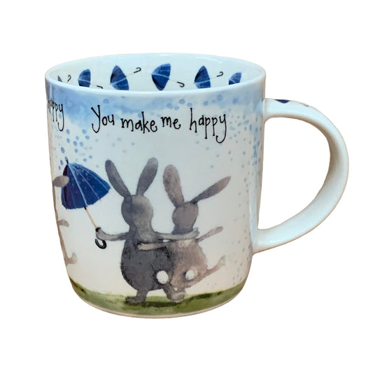 This Alex Clark mug showcases two delightful and cheerful bunny rabbits alongside the words "you make me happy" along the top of the mug. Additionally, the mug features a charming umbrella illustration around the inside rim and illustrations down the handle, adding to its whimsical appeal.
