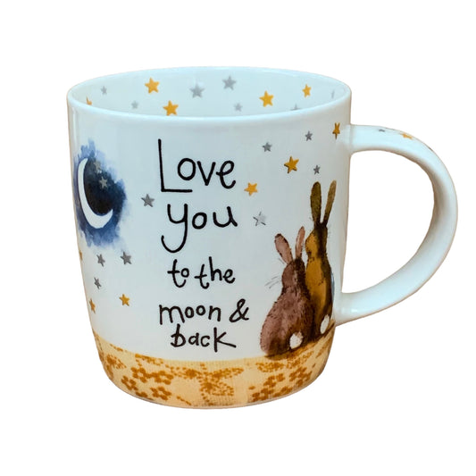 This Alex Clark mug features two lovely bunnies gazing at the night sky, accompanied by the endearing phrase "Love you to the moon & back." Additionally, the mug includes star illustrations around the inside rim and down the handle, adding to its enchanting appeal.