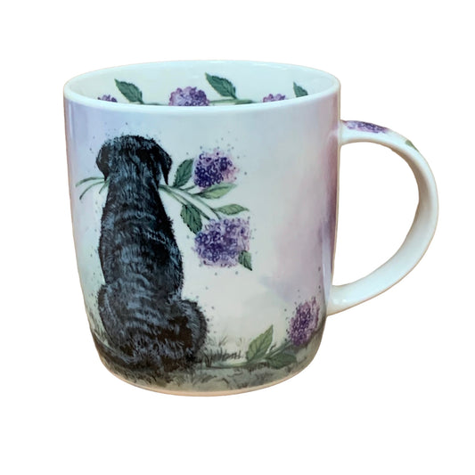 This Alex Clark mug showcases a charming Labrador admiring the view while holding a hydrangea in his mouth. Additionally, the mug features hydrangea illustrations around the inside rim and down the handle, enhancing its delightful appeal.