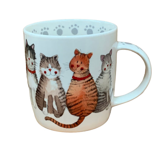 This Alex Clark mug showcases a beautiful array of different happy and content cats in its illustration. Additionally, the mug features cat paw illustrations around the inside rim and down the handle, adding to its charm. Moreover, within the same illustration, there is a matching teapot and teabag tidy, completing the delightful set.