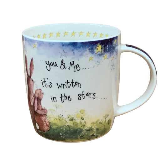 The Alex Clark mug showcases two bunnies gazing up at the night sky, accompanied by the words "You & me, it's written in the stars" on the side