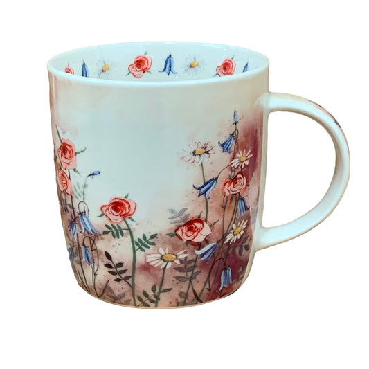 The Alex Clark mug features an illustration of a meadow full of wild flowers. Additionally, the mug includes meadow flower illustrations around the inside rim and down the handle, adding to its charming appeal.