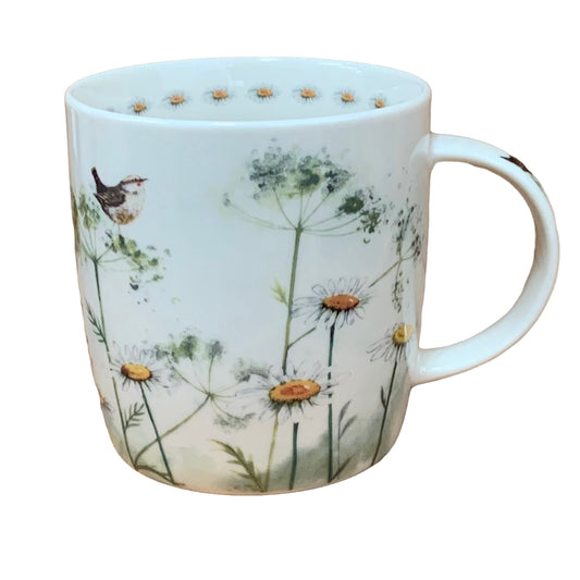 The Alex Clark mug is adorned with an illustration of a meadow featuring white cow parsley flowers and a little bird. Adding to its charm, the mug features a flower illustration around the inside rim and illustrations down the handle.