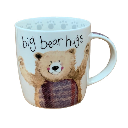 The Alex Clark mug features an illustration of a friendly bear with its arms open for a welcoming hug, accompanied by the words "big bear hugs" on the top of the mug. Enhancing its design, the mug includes a bear paw illustration around the inside rim and illustrations down the handle.