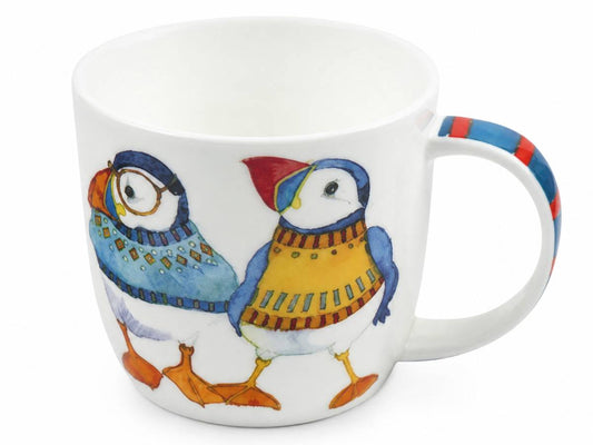 A white ceramic mug featuring a colorful illustration of two puffins wearing knit sweaters, with a striped handle in blue, red, and white.