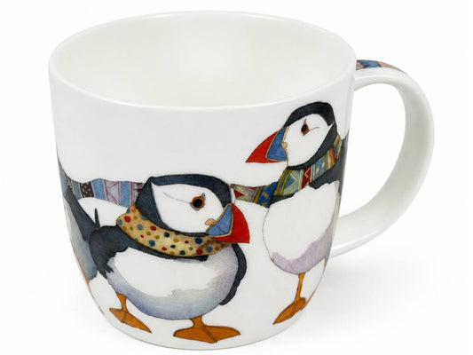 A white ceramic mug featuring a whimsical illustration of two puffins wearing colorful patterned scarves, set against a plain white background.