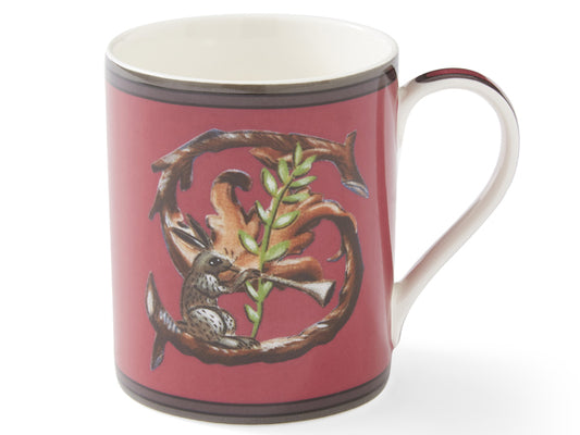 Against a rich red backdrop, the mug showcases an oak letter ‘S’, embellished with a whimsical trumpet-playing hare at its base.