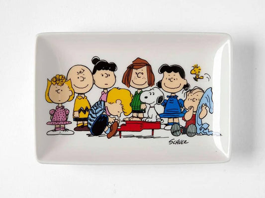 Capture the charm of the Peanuts gang with this delightful trinket tray from Magpie & Peanuts, featuring the musical prodigy Schroeder. Envision the playful melodies emanating from Schroeder's red toy piano as Charlie Brown, Lucy Van Pelt, Woodstock, and the gang gather in a heartwarming family scene. This rectangular trinket tray brings the whimsical world of Peanuts to your space, combining both charm and functionality.