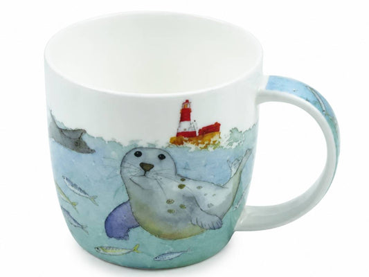 A white ceramic mug featuring a colorful illustration of a seal underwater with fish, a red lighthouse, and a blue handle.