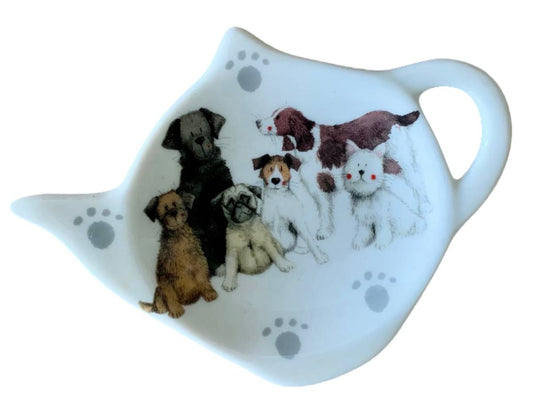 A white ceramic dog-shaped serving dish featuring a painted illustration of six different dogs and gray paw prints.