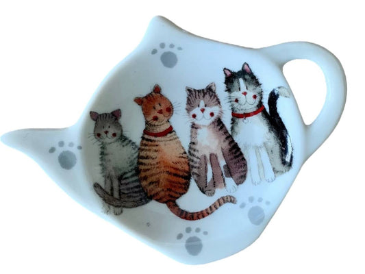 A white ceramic tea towel shaped like a teapot, featuring a printed illustration of four cute cats in various colors with gray paw prints on a white background.