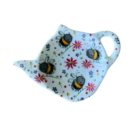The Alex Clark teabag tidy is adorned with an illustration of buzzing bumblebees frolicking in a meadow of vibrant flowers. Completing the set, the same delightful imagery graces matching teapot and mugs within the illustration.