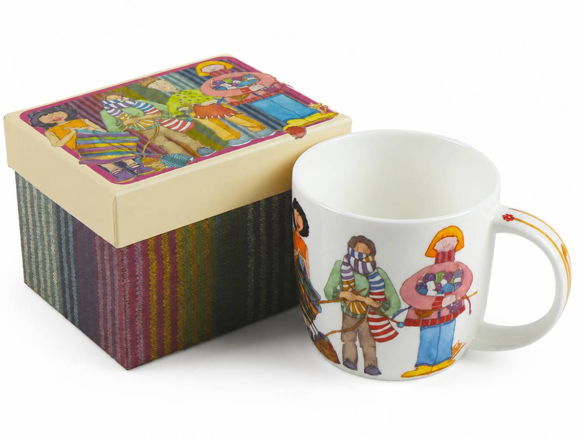 Emma Ball Yarn Club Mug featuring colourful knitters and yarn, displayed beside its matching striped illustrated gift box.
