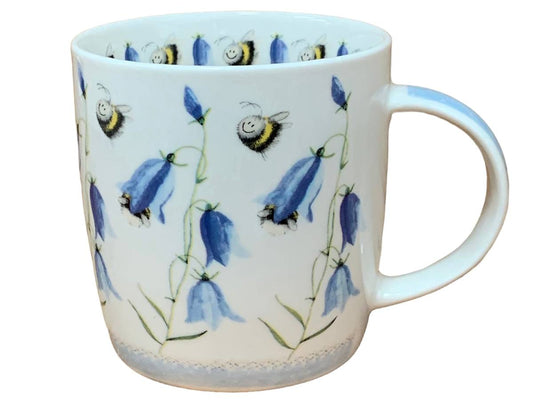 A white ceramic mug decorated with blue bell-shaped flowers and bumblebees, shown against a plain white background.