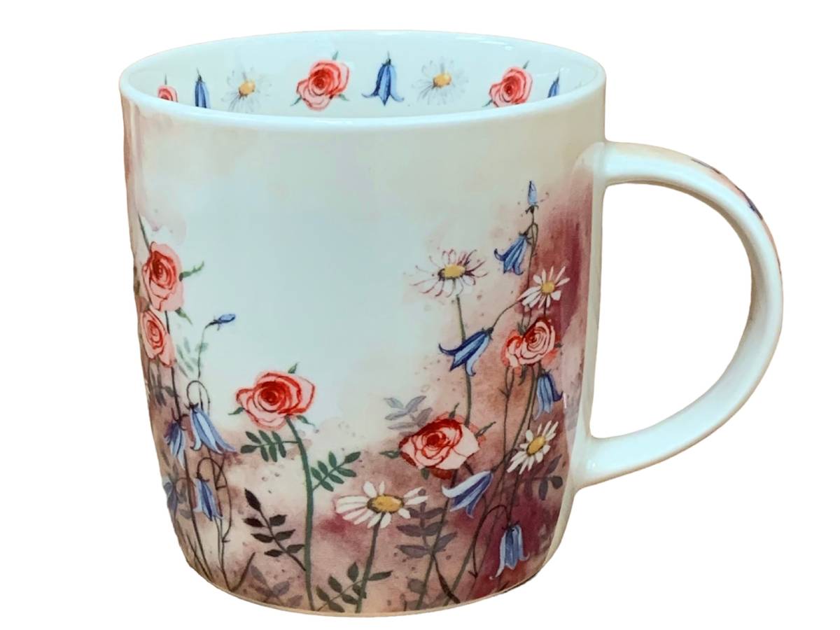 The Alex Clark mug features an illustration of a meadow full of wild flowers. Additionally, the mug includes meadow flower illustrations around the inside rim and down the handle, adding to its charming appeal.