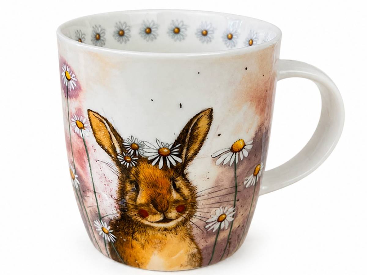A white ceramic mug featuring a watercolor-style illustration of a brown rabbit surrounded by white daisies with yellow centers, on a soft pink and beige background.
