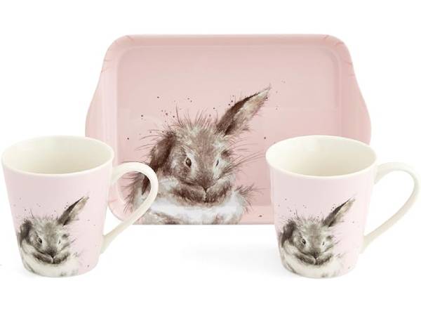A pink ceramic mug and matching rectangular tray set, each printed with a watercolor-style rabbit face. A second plain pink tray is placed behind them on a white background.