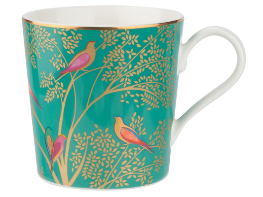Introducing the top-selling item from the Sara Miller London Chelsea collection: The Green Mug. Its rich jewel tone, adorned with pops of pink and gold accents, showcases intricate foliage and stunning bird motifs