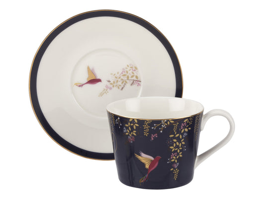 he Navy Sara Miller London Tea Cup and Saucer offers a captivating reinterpretation of the traditional teatime aesthetic. Its deep background and intricate hummingbird motif, accompanied by matching honeysuckle vines and adorned with 22-carat gold embellishments, add a touch of elegance to any stylish home. 